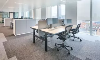 an ergonomic workplace with ergonomic office chair, standing desk and monitor arms